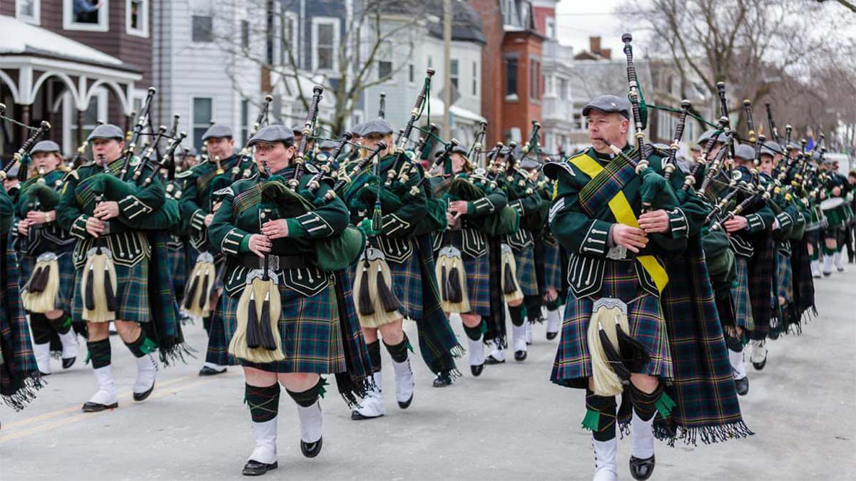 Close up of an army of people dressed in green plaid and kilts playing the bagpipes as part of the Boston St. Patrick's Day Parade in Boston, Massachusetts, USA